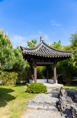 Obraz premium Angle view of a beautiful pagoda pavilion against the blue sky and green trees in Chinese garden in a public park