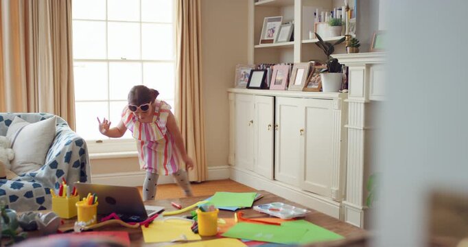 Dancing, child or girl with laptop in lounge, playful movement or internet tutorial for weekend fun. Energy, learning and happy kid with music video for choreography practice, tech or rhythm in home