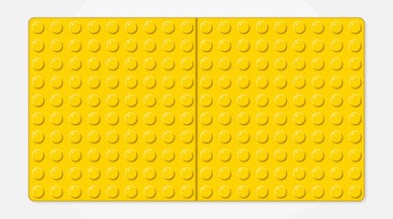 Naklejka premium Two bright yellow LEGO bricks with studded tops on a gray background, close-up studio shot for construction toy and educational play