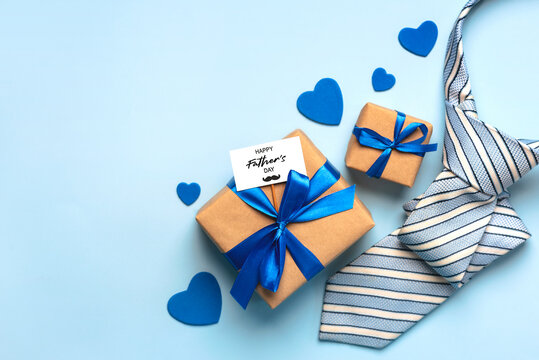 Happy Father's Day. Top view of gifts pack with white card with the text Happy Father's Day,hearts and striped necktie with space for text