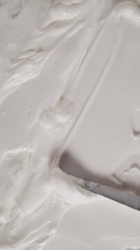 Smear of natural organic body butter cream. Skincare cream texture background for beauty product promotion, hydration treatment and clean beauty aesthetic. Vertical resolution.