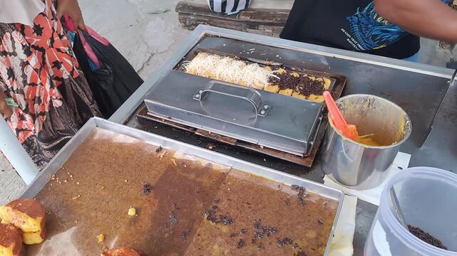 Full process of preparing Indonesian Pukis cakes: from pouring batter into hot molds, cooking, adding chocolate and cheese toppings, to displaying and packaging. Authentic Asian street food prepare.