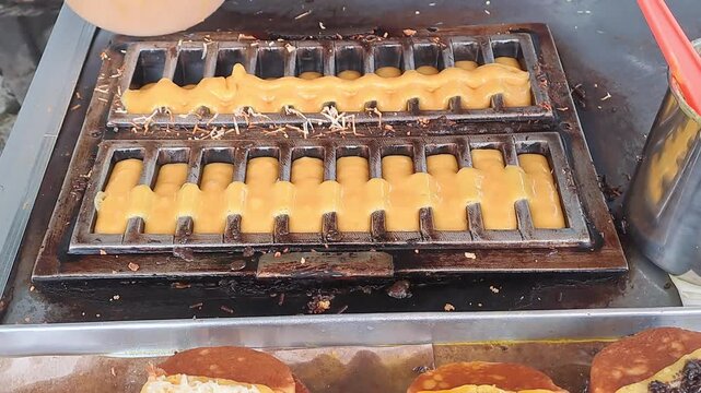 Full process of preparing Indonesian Pukis cakes: from pouring batter into hot molds, cooking, adding chocolate and cheese toppings, to displaying and packaging. Authentic Asian street food prepare.
