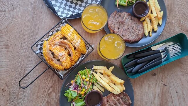 Gourmet steak house platter featuring Rib Eye, Sirloin, and Ribs Corn with a large double-meat burger. Cinematic camera movements from close-up to eagle eye view. Luxury dining experience. 4K.