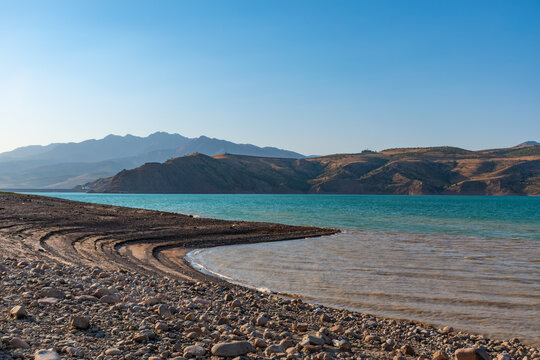 Charvak Reservoir With Rocky Shore and Mountain Landscape