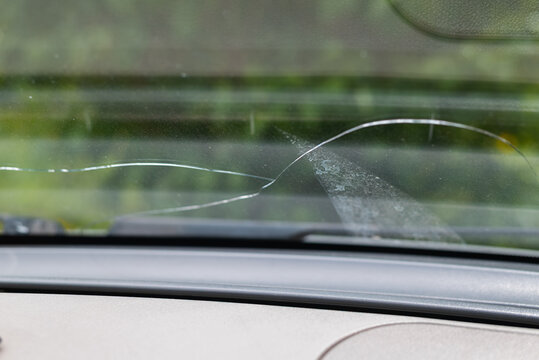 A cracked windshield shows a clear line of damage that runs across the glass.