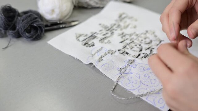 Close up of hands working with textile samples or fabric swatches on a design table, showing attention to detail in material selection and fabric composition