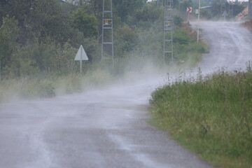 Obraz premium Rainwater Evaporating and Steaming on a Wet Rural Asphalt Road After Summer Storm