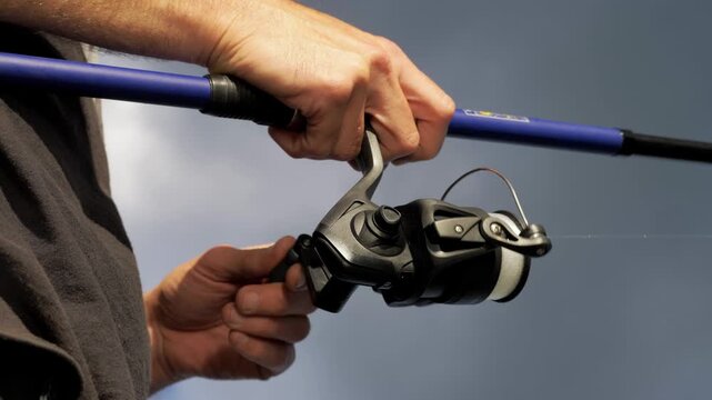 Dynamic Upward Shot of Fisherman Reeling In Line, Active Fishing Scene