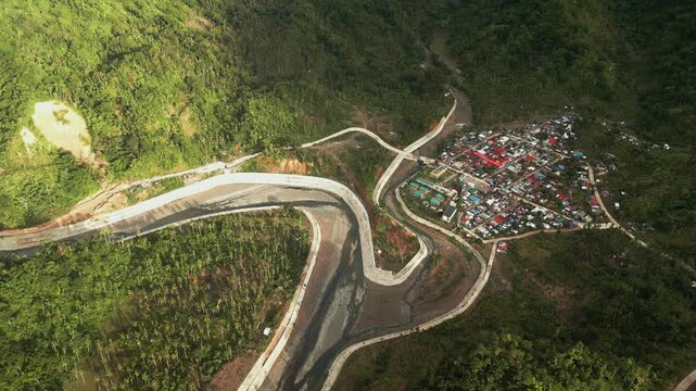 Panoramic aerial overview of Barangay Obi in Caramoran, Catanduanes, with a hillside town, winding roads, and dense tropical landscape