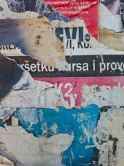 Fototapeta premium Torn and ripped street poster, grungy background, messy old paper collage