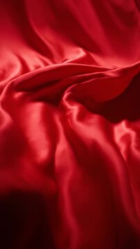 flowing luxurious red silk fabric, dramatic drapery, soft folds and elegant waves, abstract background motion