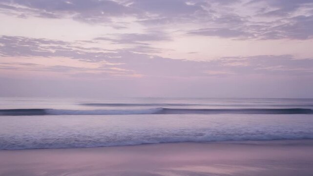 Serene purple ocean dawn pastel seascape sunrise wave gently rolling under streaked sky conveying calmness and peaceful mood