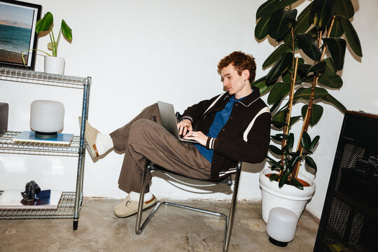 Young man working on laptop at home in a modern remote work lifestyle scene