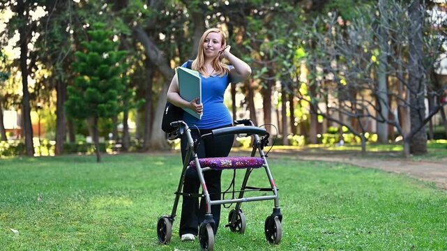 Happy young woman with walker on university campus lawn holding books and backpack - back to school, inclusive college education, student confidence and accessible campus lifestyle