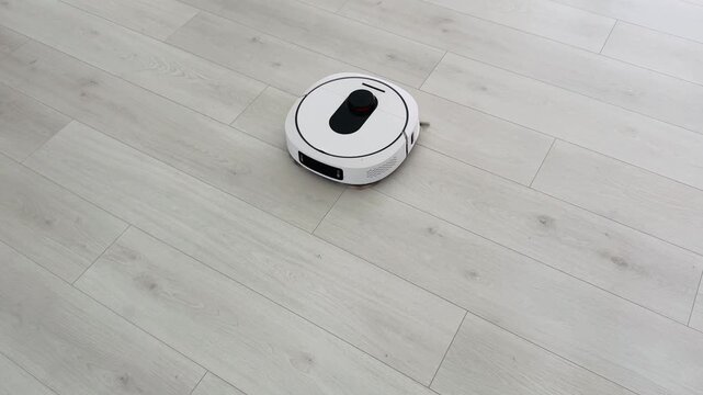 Robot vacuum cleaner navigating light wood floor in a modern living space effortlessly