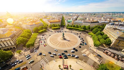 Fototapeta premium Aerial view of a bustling city street featuring a prominent roundabout with a statue at its center, surrounded by lush trees and historic buildings, showcasing urban landscape and architecture.