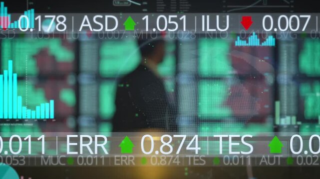 Out-of-focus wall of glowing stock trading screens showing tickers and red and green numbers in a dark room, evoking financial markets for business and economy content