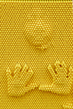 a close-up, high-angle shot of a classic bright yellow pin art toy