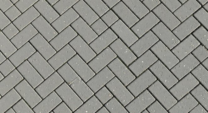 Grey rectangular paving stones arranged in a herringbone pattern