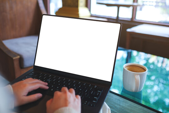 Mockup image of a woman working and typing on laptop computer with blank white desktop screen in cafe