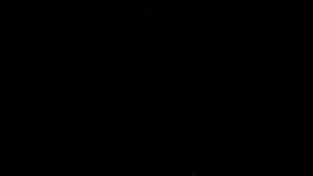 Realistic fire sparks and hot embers floating up in the dark.