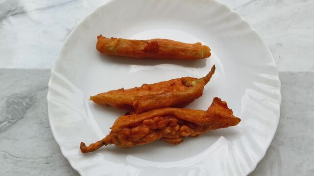 Closeup top view of traditional south indian kerala spicy tea snack mulaku bajji served on plate with white background.