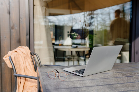 Remote Work Setup On Cabin Terrace With Laptop And Forest View