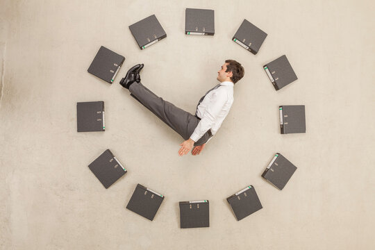 Businessman inside circle of files forming clock