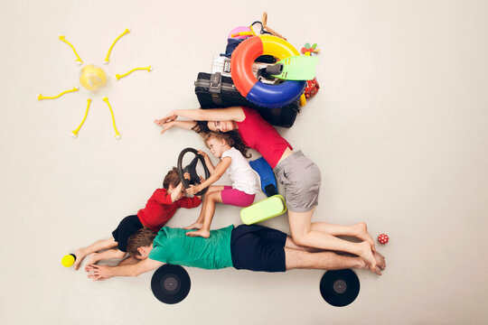 Family playing with travel props in an imaginative road trip scene