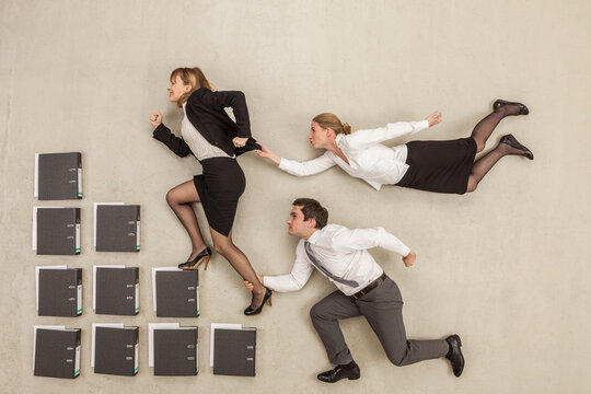 Businesswoman on staircase of files while others chasing