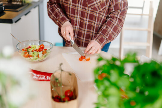 Preparing Fresh Garden Salad With Cherry Tomatoes In Modern Cabin Kitchen