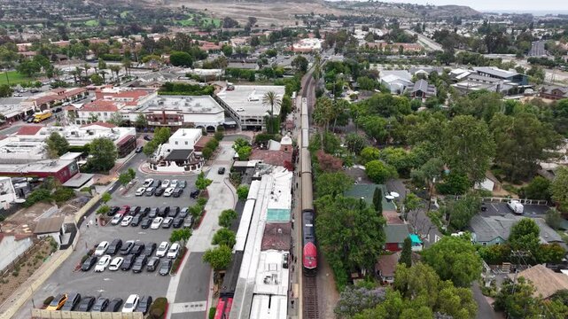 A slow glide above the San Juan Capistrano Train station where we see passengers moving about beside the train