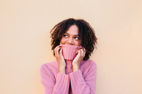 Portrait of young woman wearing pink pullover