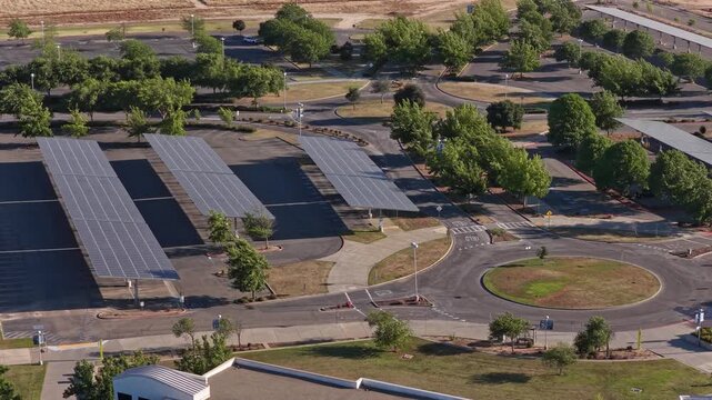 Aerial view of a modern college campus parking lot in Fresno, California, featuring solar panels installed over the parking spaces to generate clean, renewable energy and provide shade for vehicles