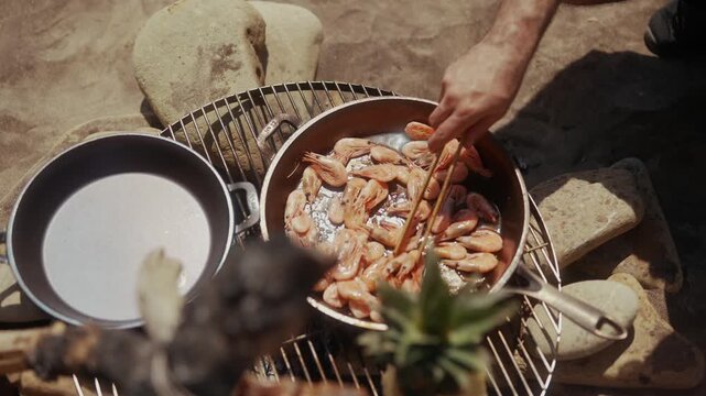 Shrimp cooking in a pan on a grill outdoors
