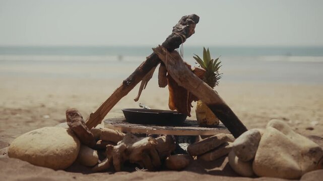 Cast iron pan cooking setup on a sandy beach