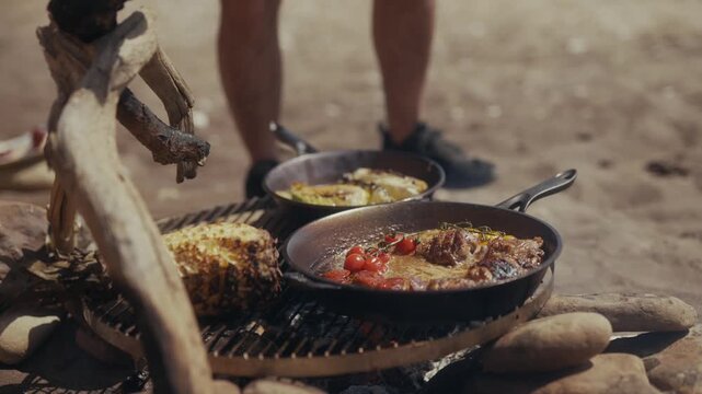 Cooking food in cast iron pans over an open fire