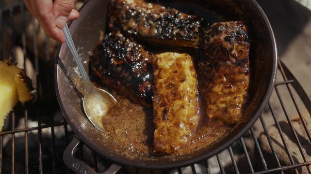 Cooking glazed fish and pineapple in a cast iron pan