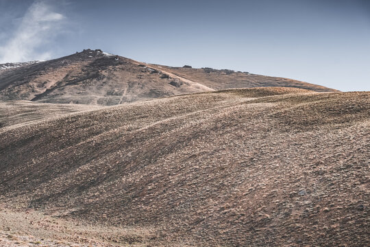 Rocky mountain slopes in the Pamir Mountains in Tajikistan, a minimalist landscape and rocky hills in sunny weather