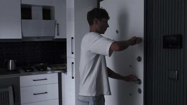 Agoraphobia and paranoia concept with frightened man quickly locking apartment door, fear, anxiety, unsafe world and psychological panic atmosphere