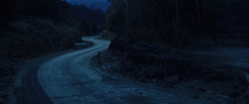 Dimly lit roadway at night with emphasis on soil erosion threats