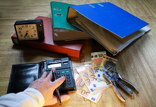 Contabilidad, finanzas, declaraci&oacute;n de la renta y econom&iacute;a countable con calculadora, dinero cash money y carpeta con reloj y grapadora
