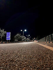 Empty Road at Night with Street Lights from Low Angle with Signs © Faizan