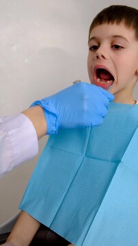 A child at the dentist gets his teeth treated. Selective focus.