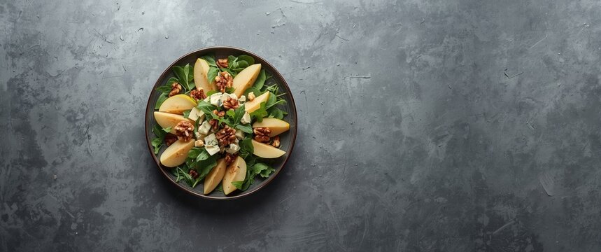 Flat top view on gray stone matte texture backdrop featuring French autumn salad incorporating pears walnuts and blue cheese and copy space