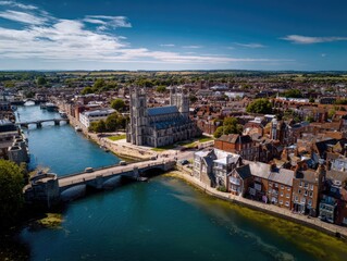 Obraz premium Aerial view of historic town with cathedral and river, under a bright blue sky