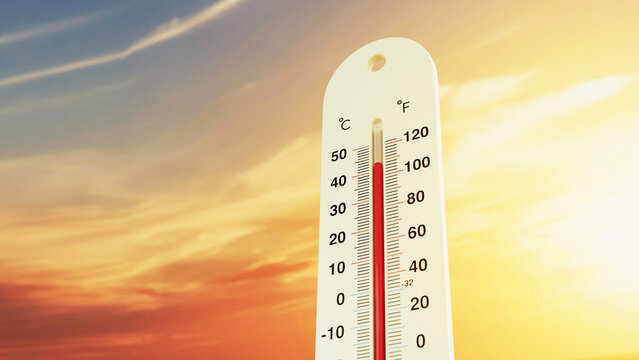 An outdoor thermometer showing dangerously high temperatures against a dramatic orange and yellow sunset sky, conceptualizing global warming, an extreme summer heatwave, and climate change crisis.