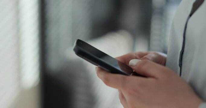Close-up young woman using smartphone in living room at home. Girl using texting mobile phone or chat. Chatting on social networks online.