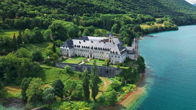 Aerial shot around Hautecombe Royal Abbey on a sunny day on the shores of Lac du Bourget in Savoie departement, Auvergne Rhone Alpes region, France